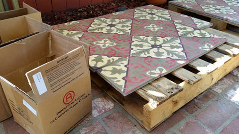 Cement tiles are removed from the box and placed on pallets prior to applying a grout release