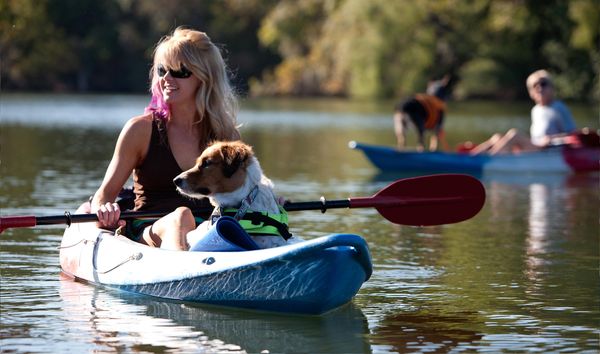 Lady and dog kayaking on lake