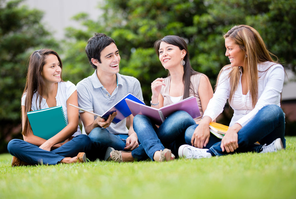 students sitting on grass 