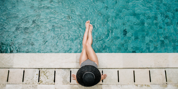 Woman sitting at blue swimming pool