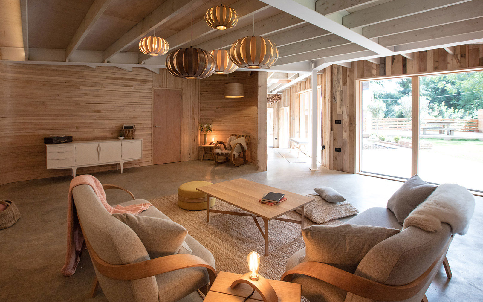 The living room at Tom Raffield's house, with steam-bent wooden walls and furniture