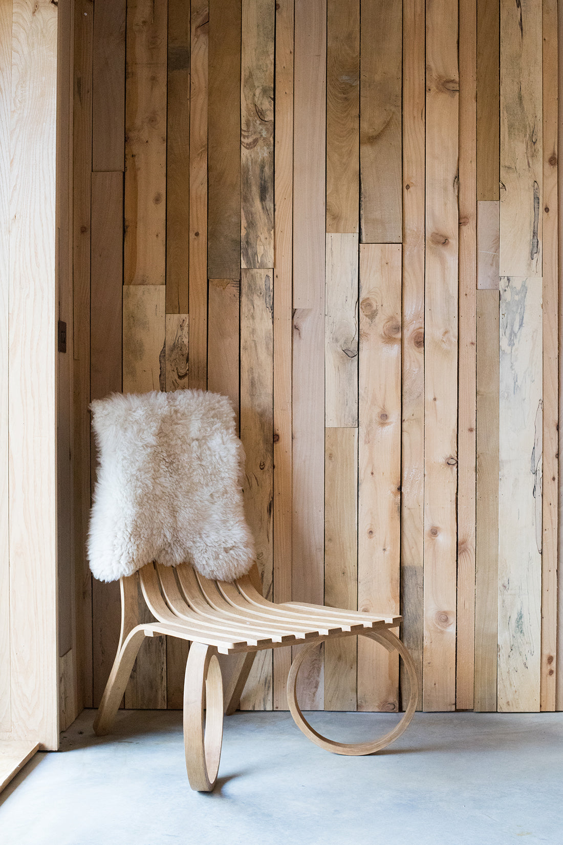 Steam bent wooden chair with sheepskin rug