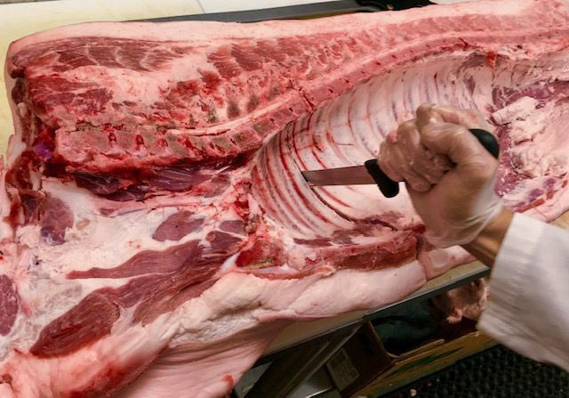 photo of pork being trimmed into pork shoulder
