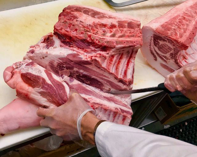 photo of pork shoulder being trimmed from pig