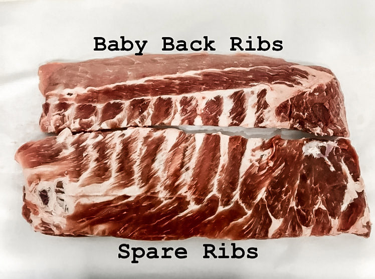 Full rack of ribs cut in half to show the smaller baby back ribs on the top and the larger spare ribs on the bottom