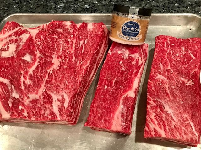 raw beef short ribs with salt container next to them