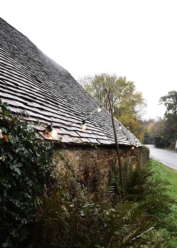 Ancient barn, home to Wild Sussex, with twinkling fairy lights.
