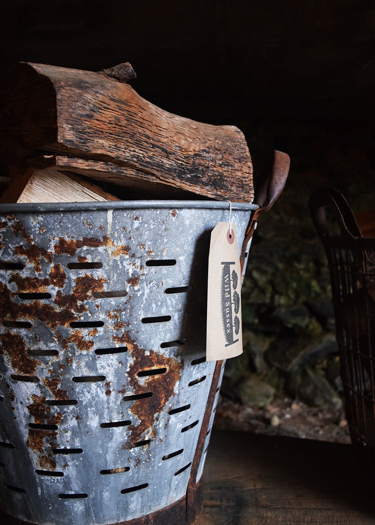 Locally sourced logs and vintage metal basket at Wild Sussex shop.