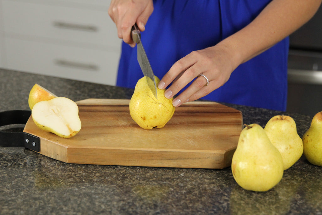 woman in blue dress cutting a pear