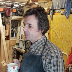 Simon in his workshop holding tea!