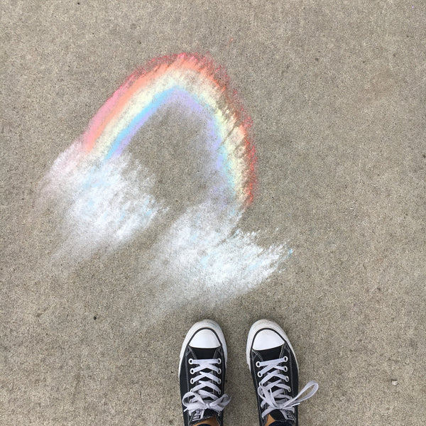 Stacy Davison's feet next to a chalk-drawn rainbow
