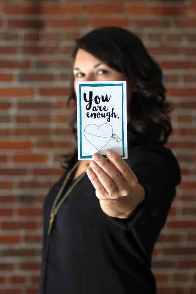 Stacy Davison, holding a Personal Pep Talk strategy card that says "you are enough"
