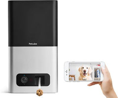A machine called the pet cube that is pushing out a dog treat while someone is controlling a phone where they can see a light colored dog in front of the machine | Bubu Brands 