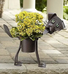 15 Perfect Gifts to get a Dog Lover | A dark colored dog shaped flower pot with small light colored flowers as the body | Bubu Brands