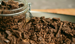 A glass jar filled with dark chocolate pouring onto a counter | Bubu Brands