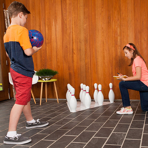 boy and girl with bowling set indoors