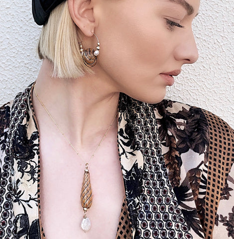 Image of Model wearing Leoni & Vonk venetian bead and pearl necklace, a Zara jacket and a Murley & Co hat