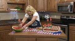 Kristi placing the wooden skewers with watermelon stars into the other watermelon bowl
