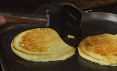 RADA Non-Scratch Spatula hovering over a couple pancakes on a griddle