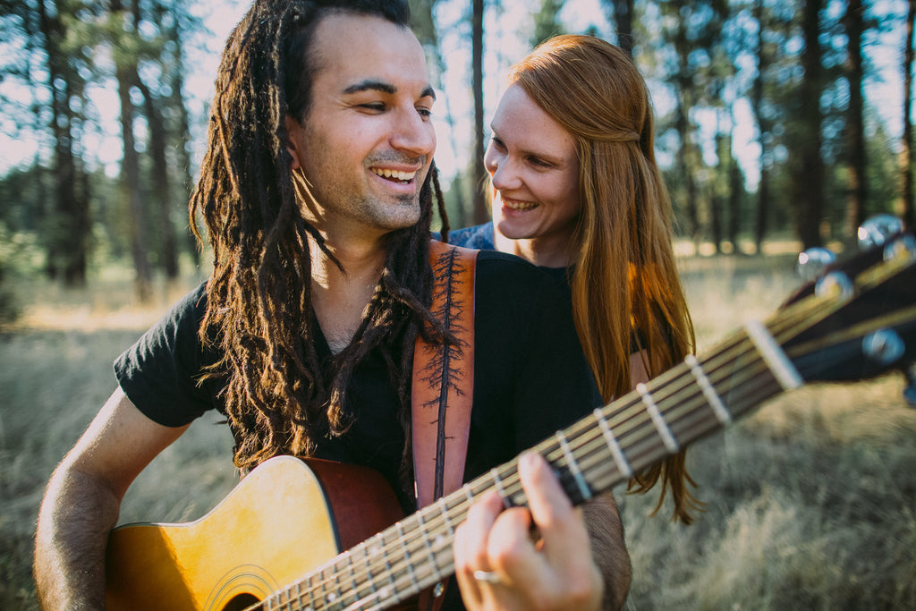 Owners of Colladay Leather share a laugh and a tune on the guitar. Jeremiah is wearing the Lodgepole Pine Guitar Strap. 