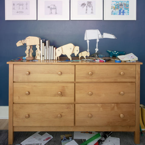 a wooden dresser with wooden Star Wars AT-AT and wooden bison