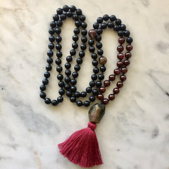 Knotted 108 mala necklace with pink tourmaline and deep red cotton tassel