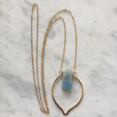 aquamarine stone necklace with gold decorative frame and gold chain