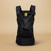 LÍLLÉbaby black complete all season carrier against beige backdrop