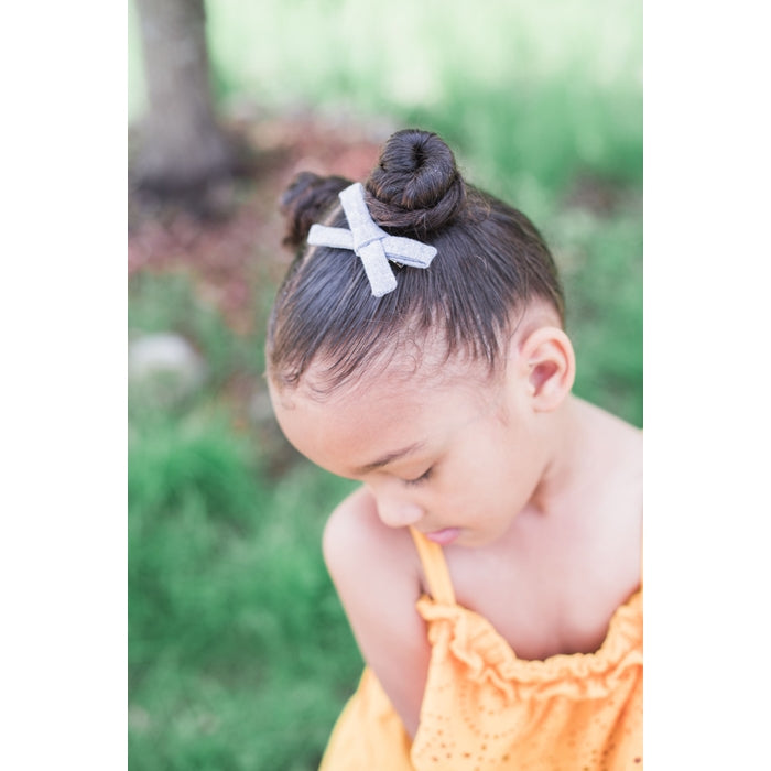 ThisLittlePiggyBowCo. light chambray schoolgirl hair bow model in lifestyle imagine. 