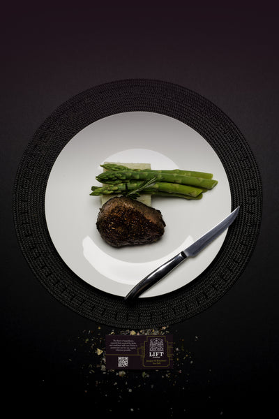 Steak with asparagus and Lift Juniper & Rosemary Salt label, purple ombre/black background
