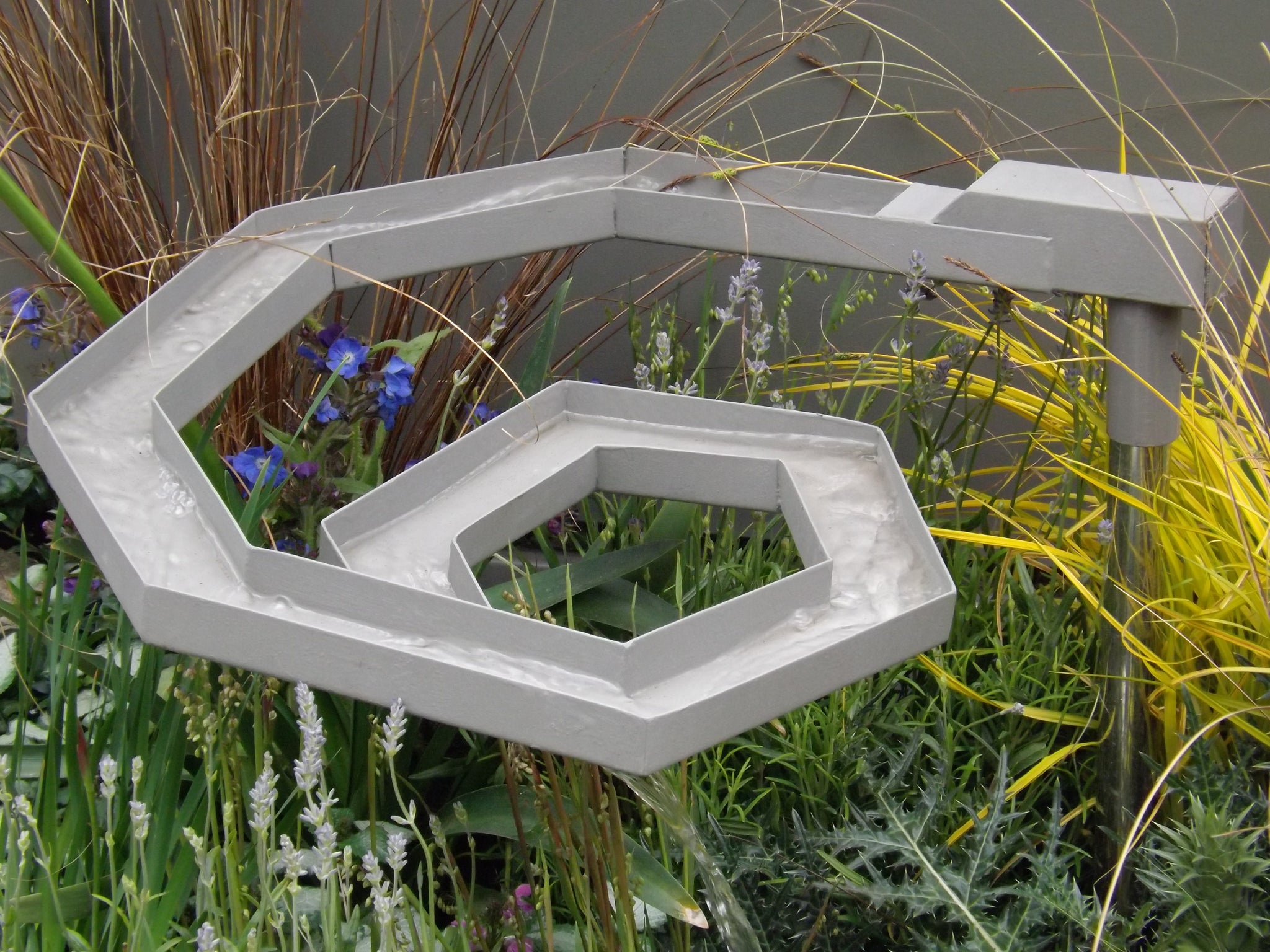 A spiral rill echoes the angular metal elsewhere in the garden