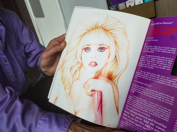 Scott Hennig shows off his published drawings of Angelyne.