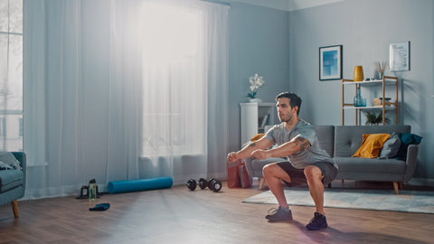 A man doing squats at home.