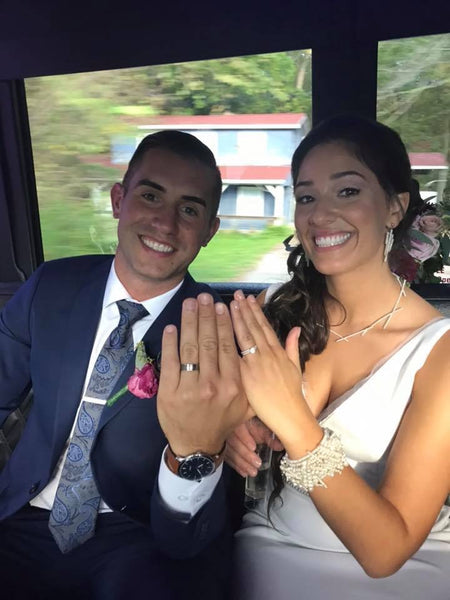 Bride and groom showing off wedding rings