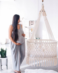 pregnant woman watching a cradle in the kids room