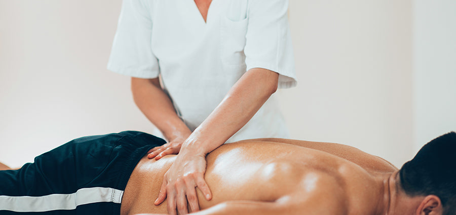 Adult man getting a back rub with CBD oil. Buy massage oil with CBD online.