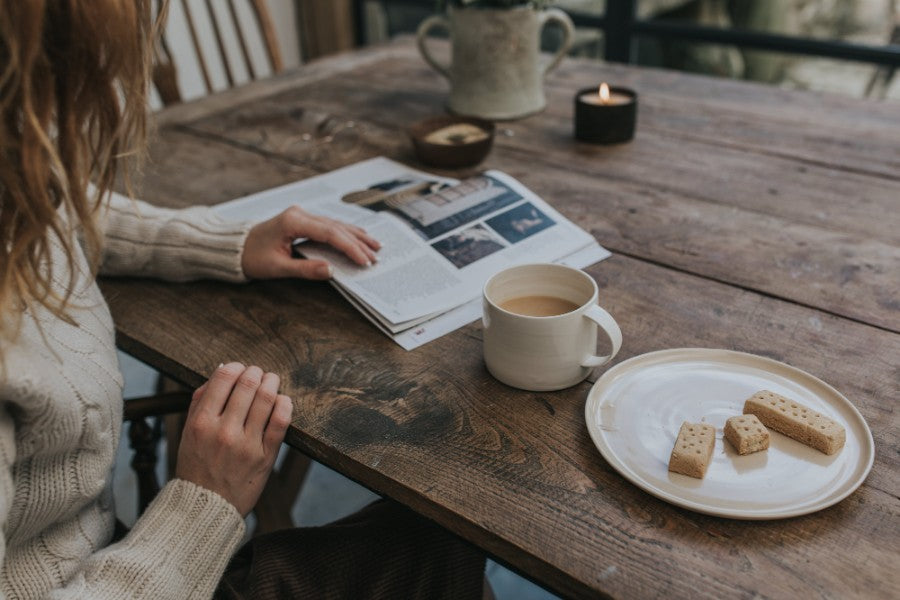 Girl enjoying a cup of tea and biscuits with Barton croft mug and plate