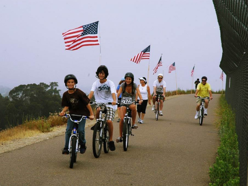 Kids riding on bicycles with American flags