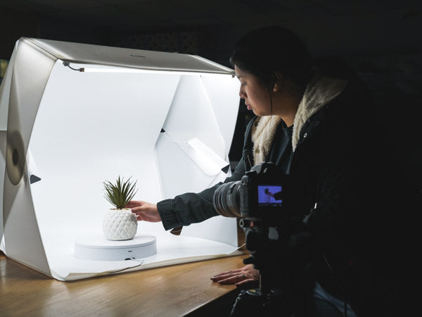 woman using the foldio light tent for product photography