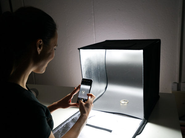 woman using the hypop studio buddy light tent to photograph ring