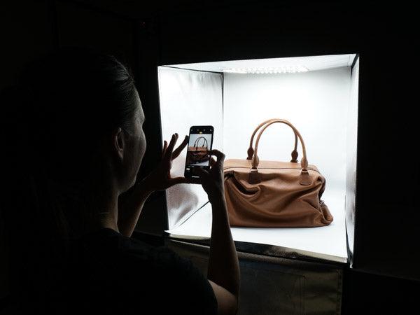 woman using the hypop studio buddy light tent to photograph handbag