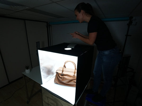 woman using the hypop studio buddy light tent to photograph handbag