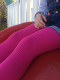 Close up of child's knees wearing bright pink tights.