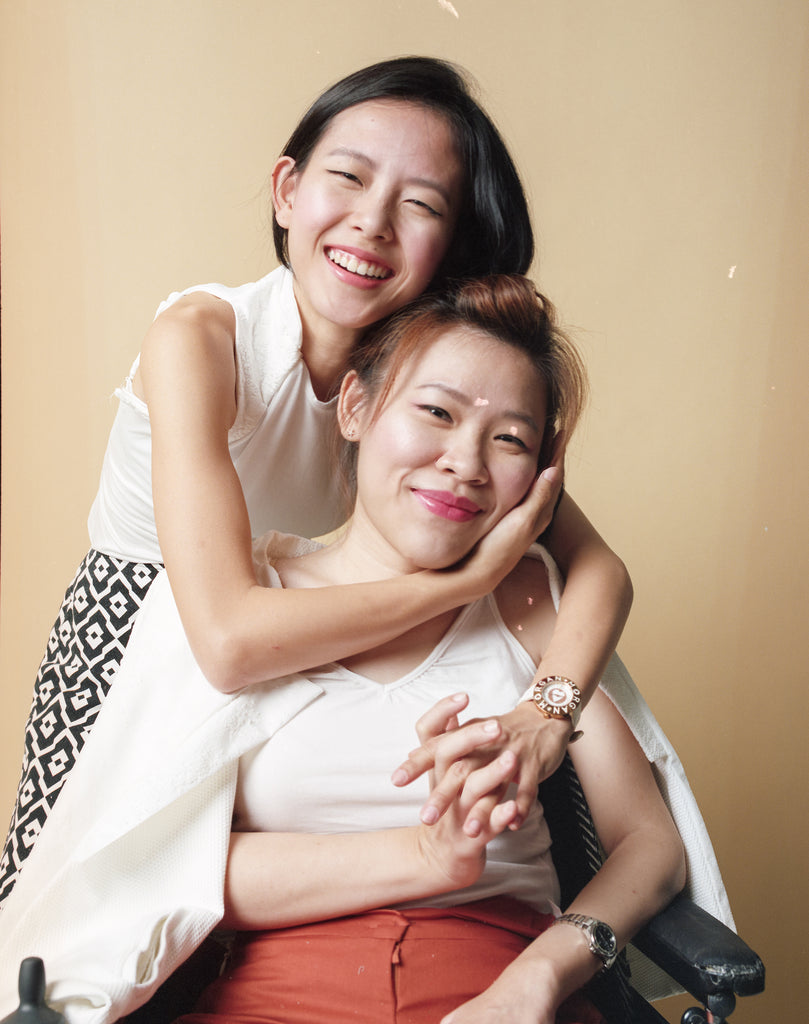 Elisa embracing Yean Cheng from the back as they smile into the camera