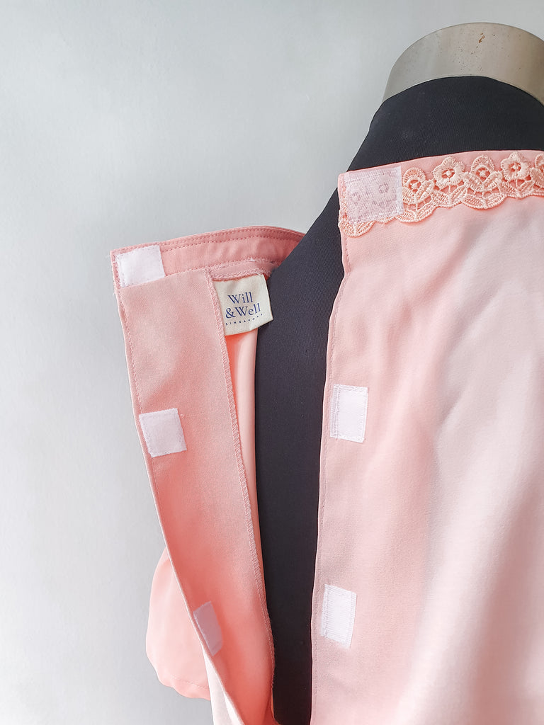 Multiple Velcro attachments at the back of the pink blouse. Will & Well label visible on the inside of the blouse.