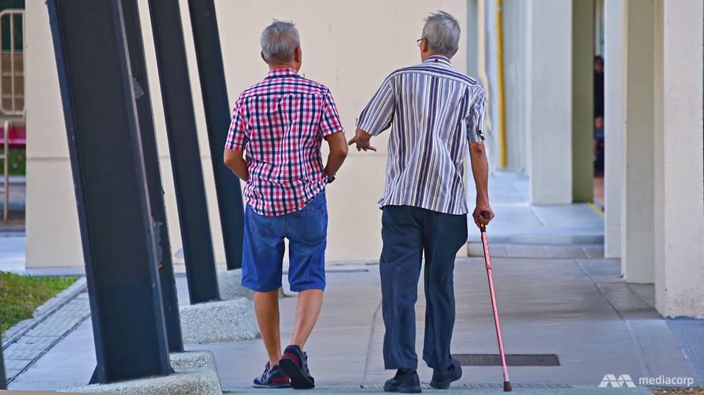 Two elderly men walking at a void deck in Singapore.