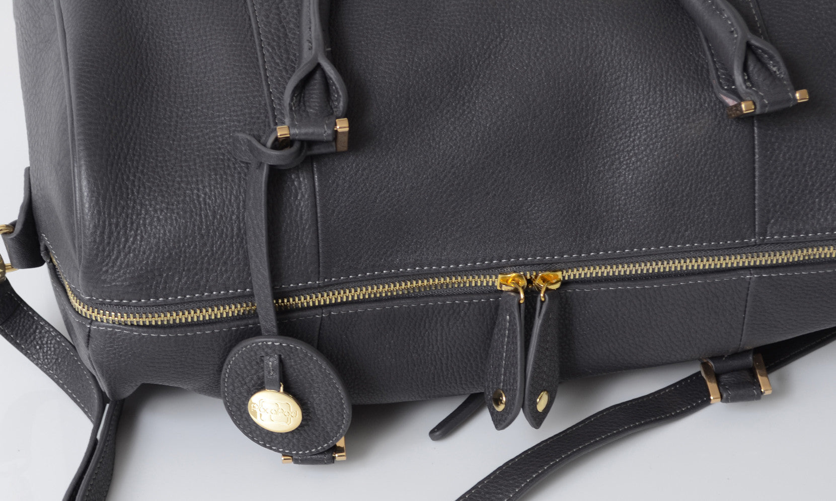 Close up of a grey leather bag with gold zip