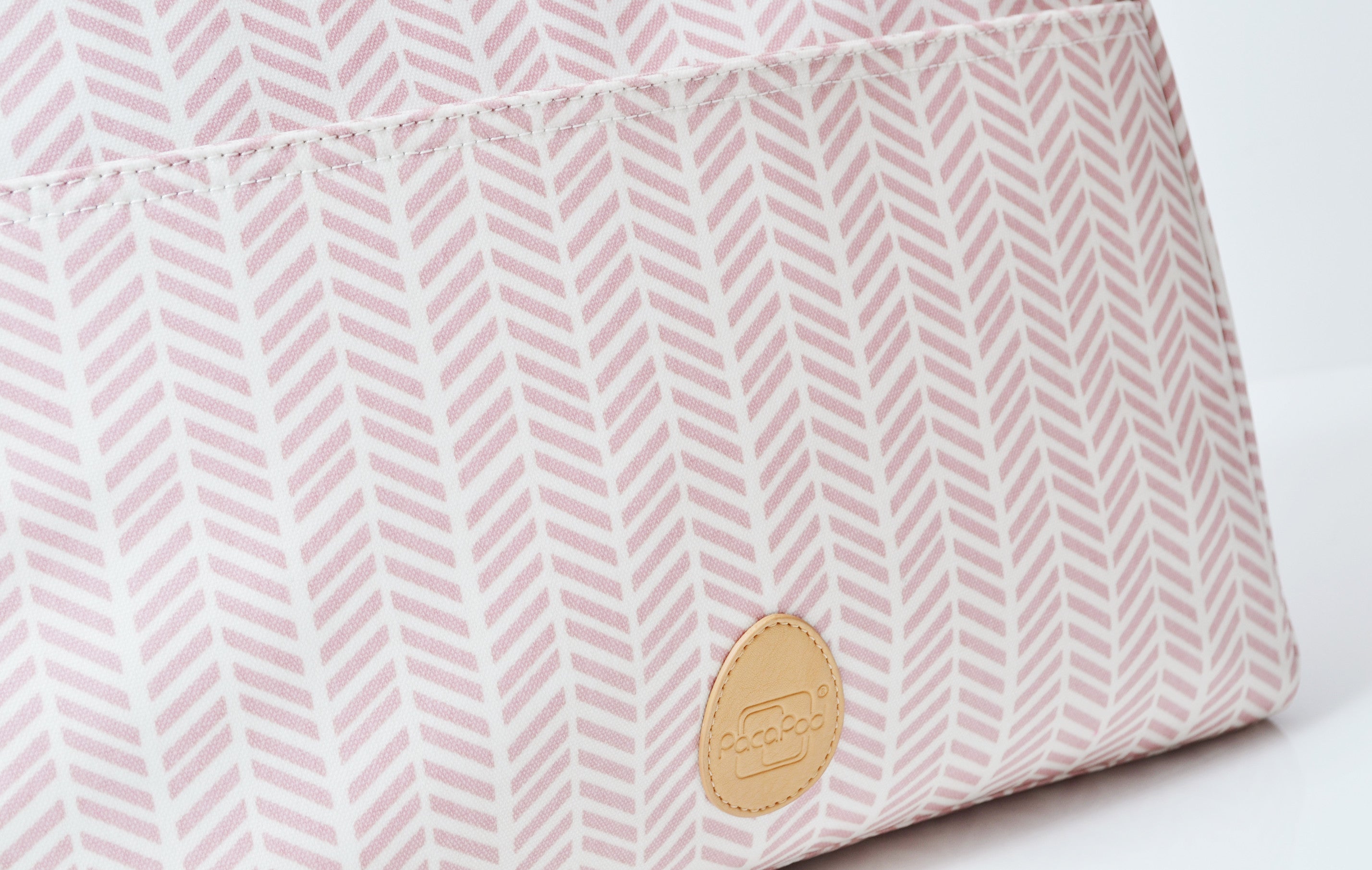 Close up of a cream fabric with a pink line print