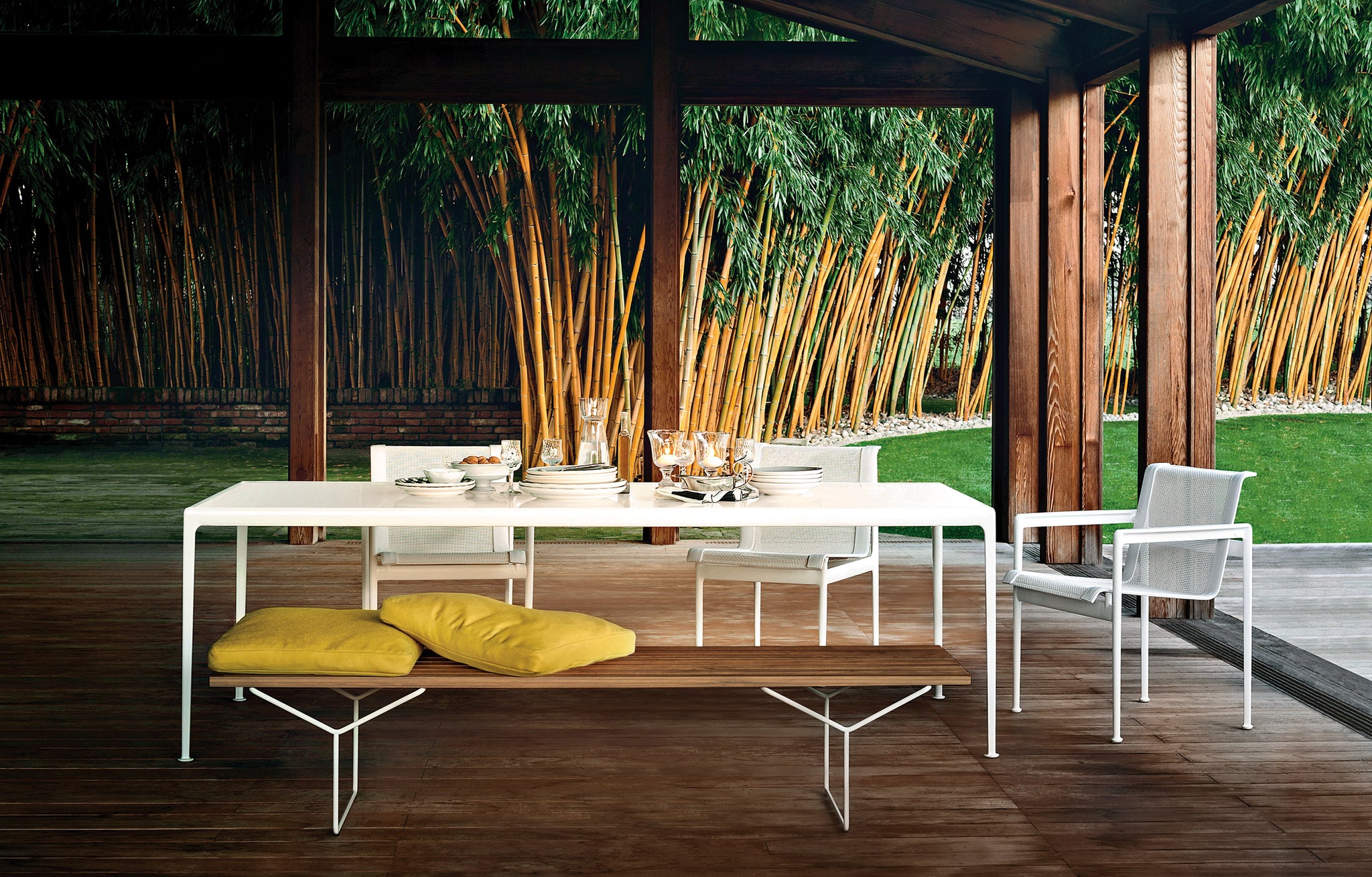 Knoll Outdoor Chairs and Bench around an Outdoor Table on Porch