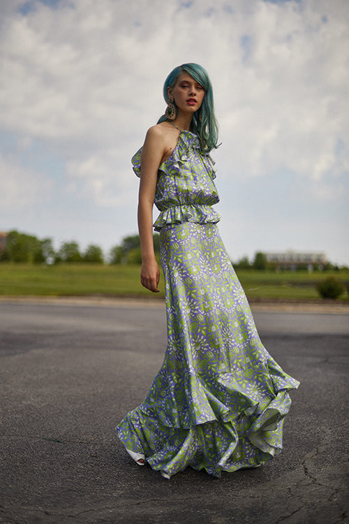 Cynthia Rowley Resort 2019 Collection features a light green and purple floral printed maxi dress finished with ruffles at the bottom of the dress. 